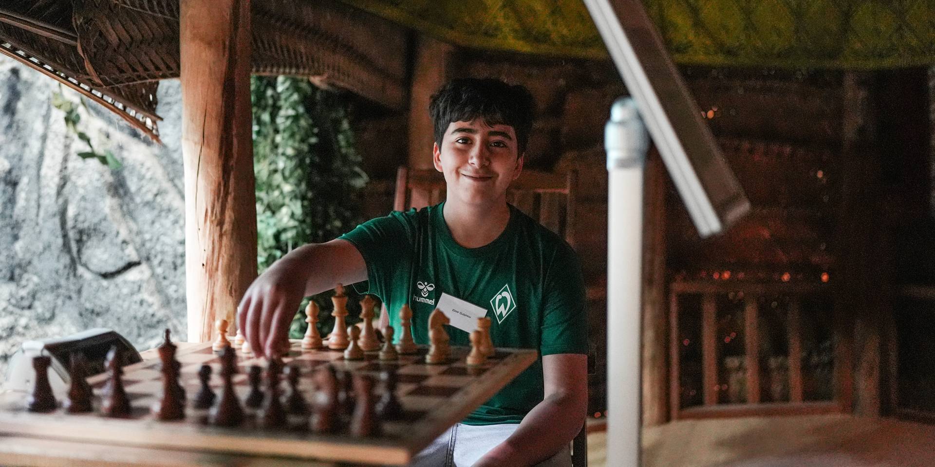 SVW Schach Spieler hält Figur in der Hand und lächelt in die Kamera