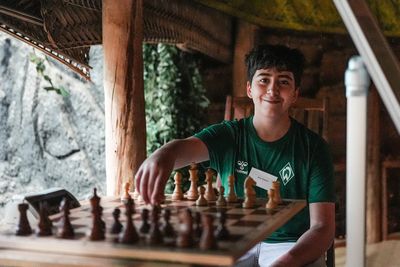 SVW Schach Spieler hält Figur in der Hand und lächelt in die Kamera