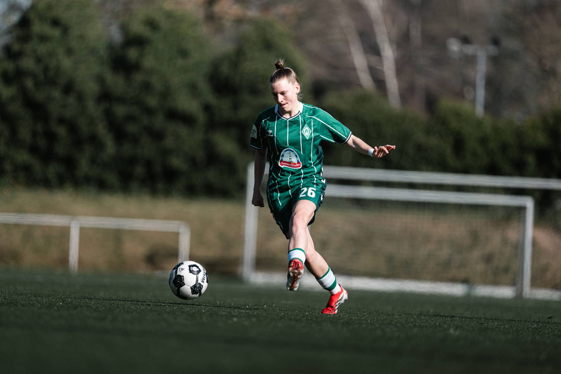 Sarah Ernst setzt zum Pass an im grünen Heimtrikot.