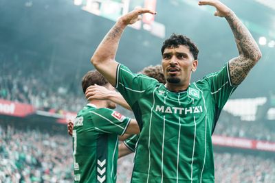 Cameron Puertas im grünen Trikot hat seine tätowierten Arme in die Luft gerissen. Hinter ihm sind weitere Spieler in Grün zu sehen.