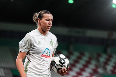 Larissa Mühlhaus schaut nach unten und hält den Ball in der linken Hand.