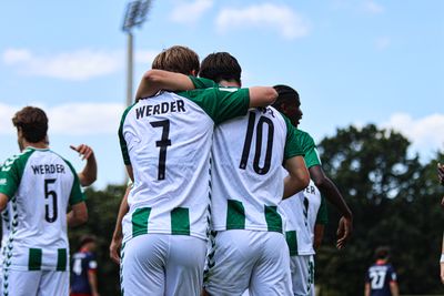 Zwei Spieler der U19 umarmen sich und stehen mit dem Rücken zur Kamera.