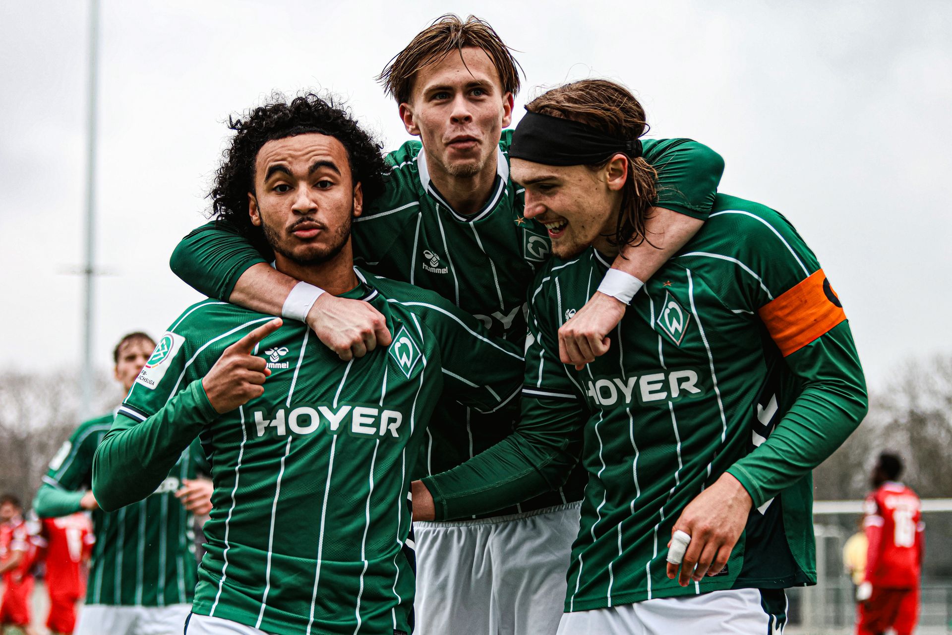 Drei Spieler der U19 umarmen sich und bejubeln ein Tor.