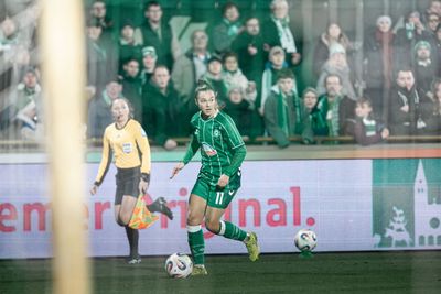 Maja Sternad im grünen Trikot mit der Nummer 11 dribbelt den Ball auf dem Spielfeld, ein Schiedsrichter steht daneben; im Hintergrund sind Zuschauer und eine Anzeigetafel zu sehen.