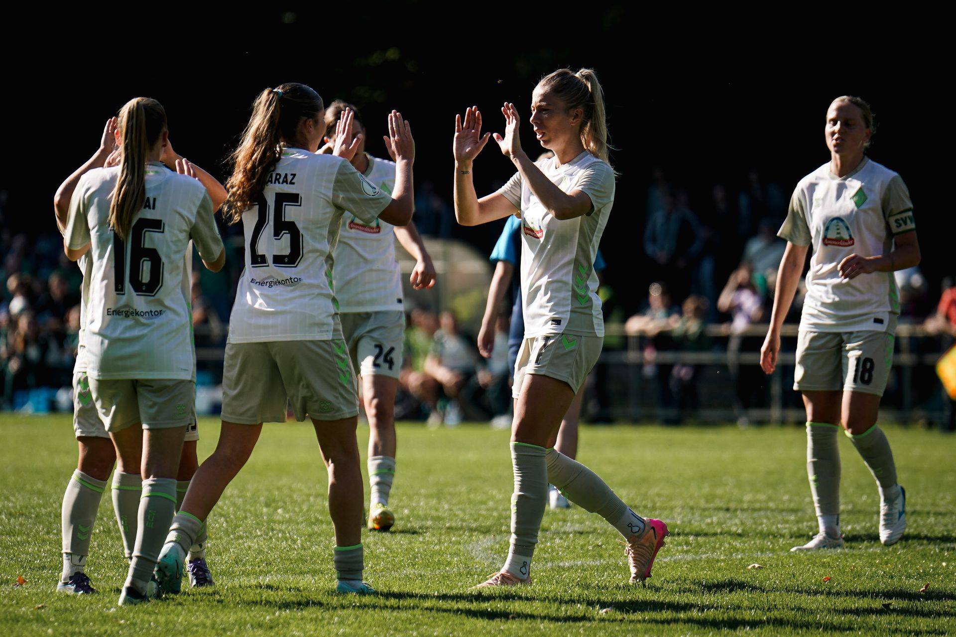 Werders Spielerinnen klatschen nach einem Tor gegen Victoria miteinander ab.