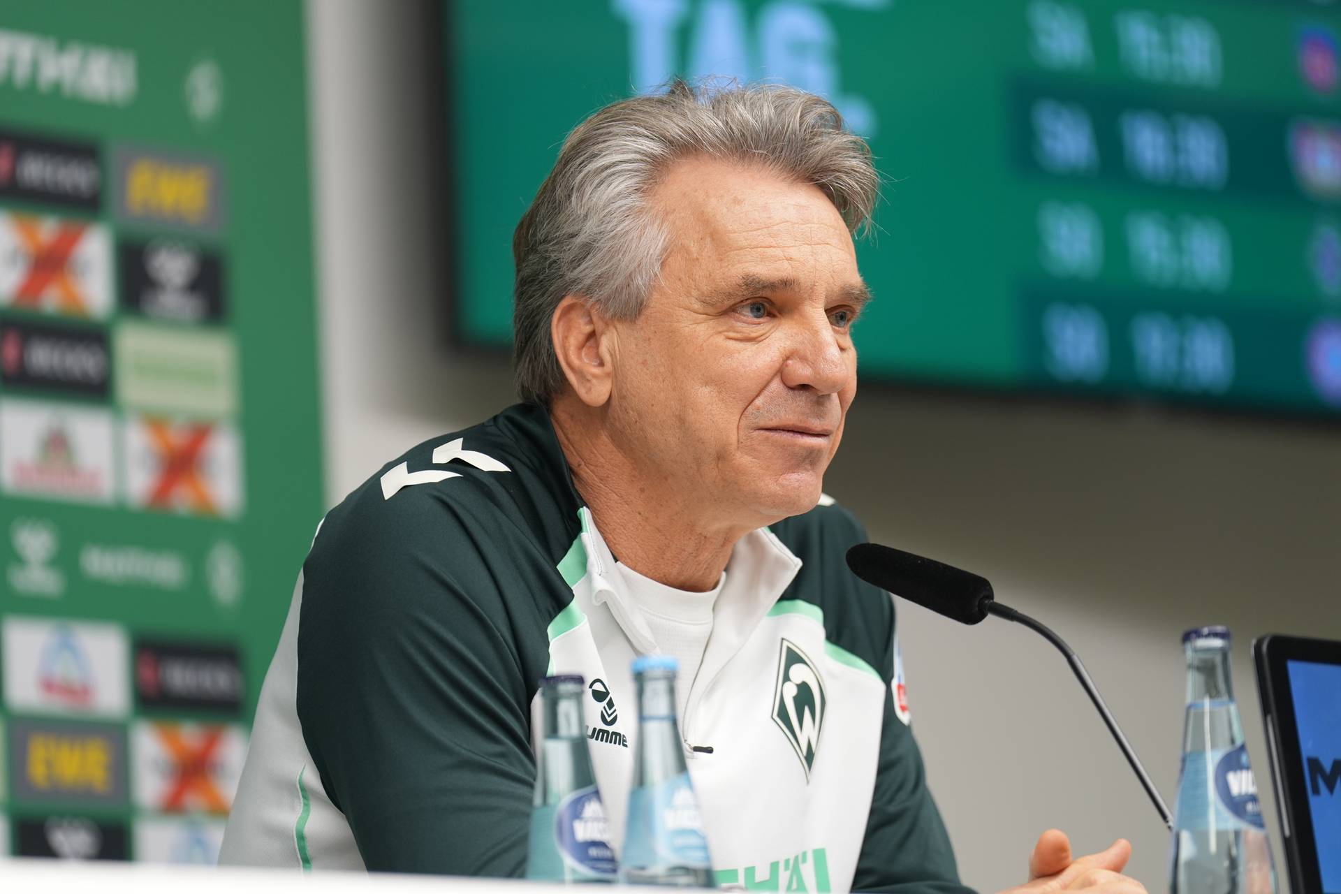 Horst Steffen mit entschlossenem Blick in Großaufnahme auf der Pressekonferenz vor dem Heimspiel gegen die TSG Hoffenheim.