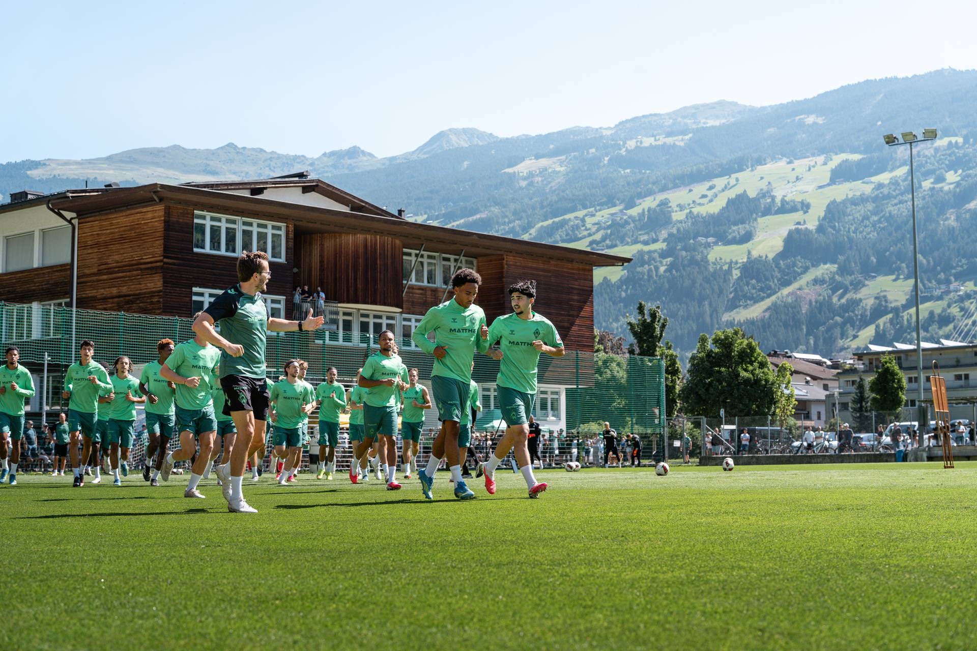Die Mannschaft läuft sich warm, im Hintergrund die Berge.