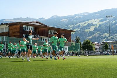 Die Mannschaft läuft sich warm, im Hintergrund die Berge.