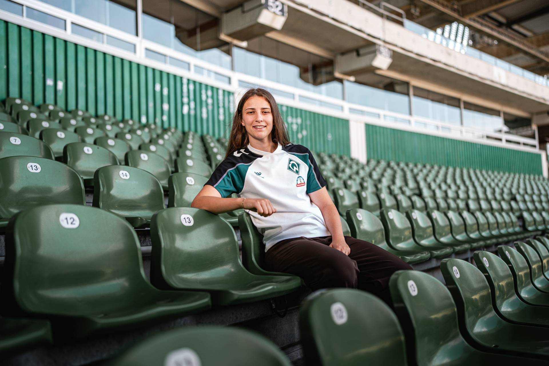Julia Magerl sitzt auf einer Tribüne im Stadion.
