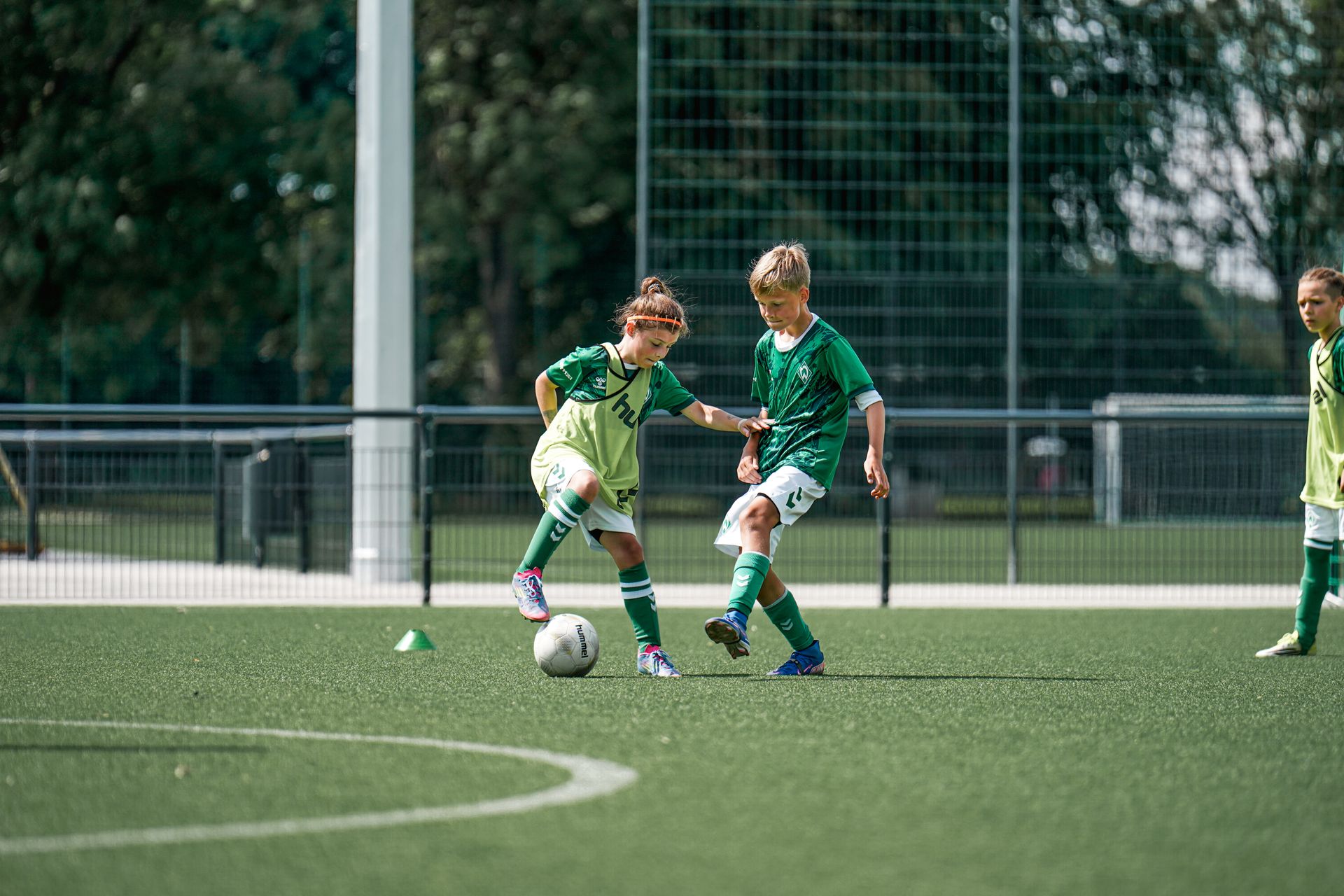 Zwei Kinder aus dem Sommer Camp der Fussballschule führen einen Zweikampf.