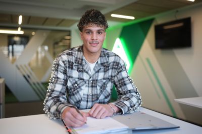 Yasin Chebil, ein junger Mann, sitzt an einem Tisch und unterschreibt einen Vertrag.