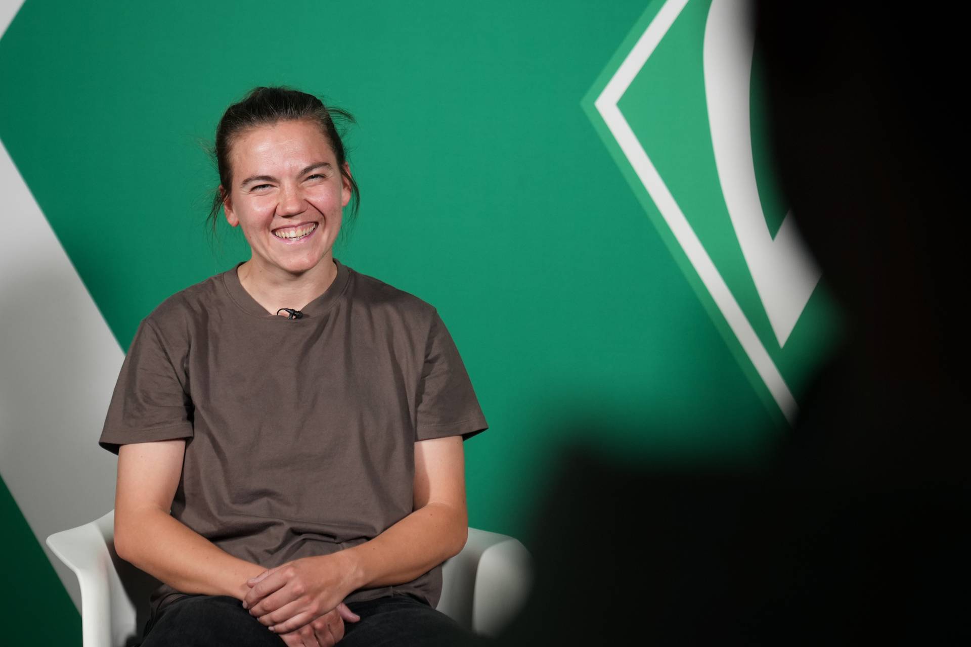 Rieke Dieckmann sitzt auf einem Stuhl und lacht.