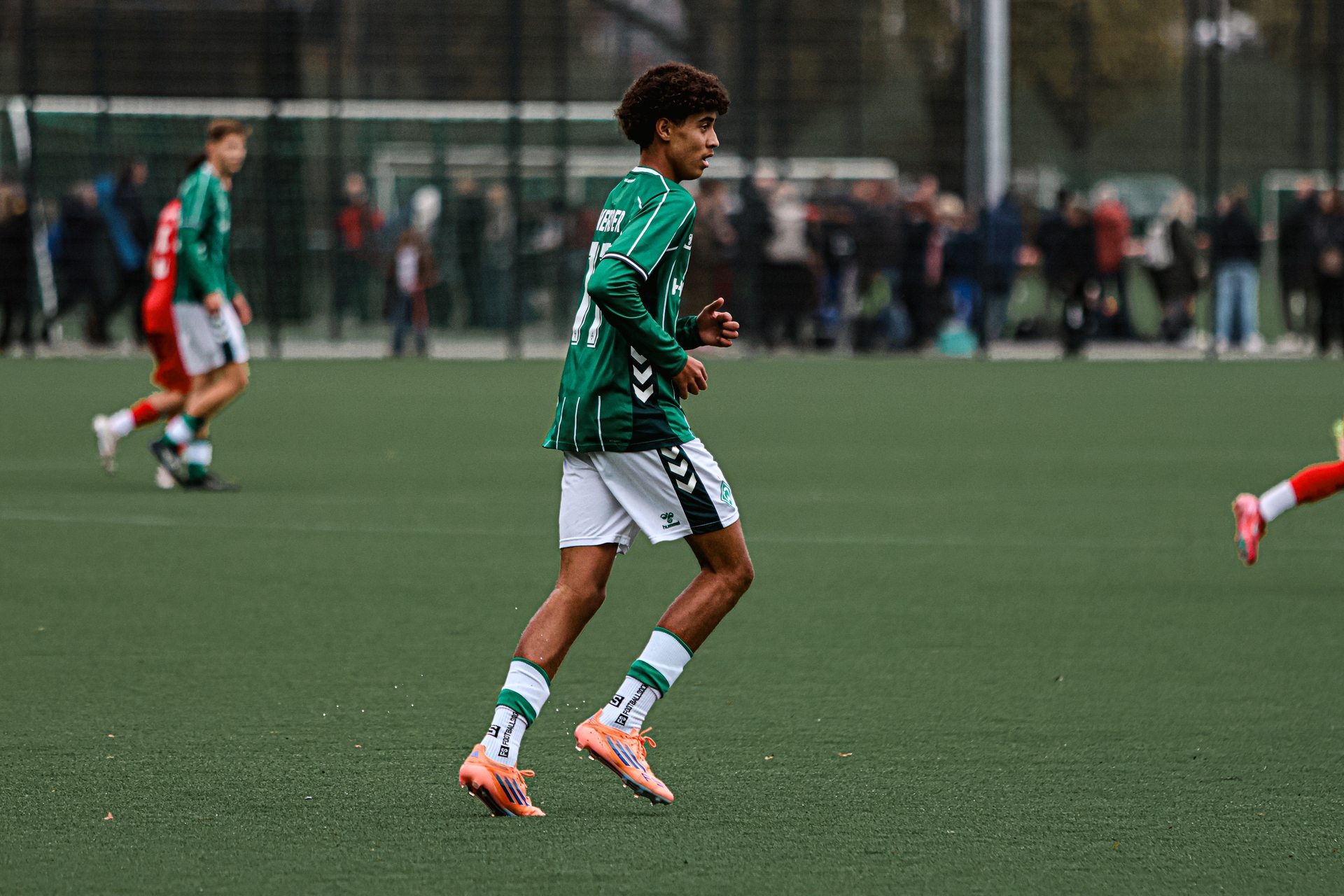 Ein Spieler der Werder-U16 im grün-weißen Dress läuft in Richtung der rechten Bildhälfte