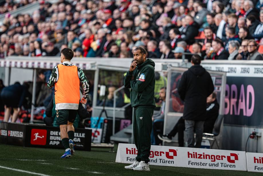 Daniel Thioune an der Seitenlinie mit der Hand vor dem Mund und guckt nach oben in Freiburg