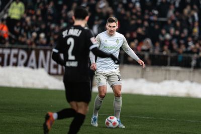 Maximilian Wöber am Millerntor im Werder-Trikot mit Ball am Fuß.