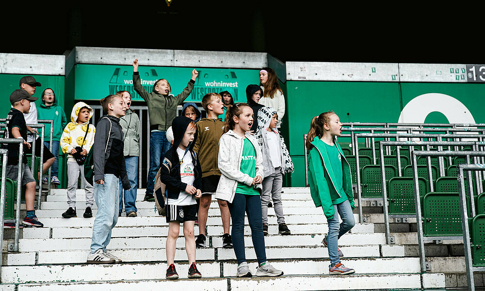 Kinder jubeln auf der Tribüne des Weserstadions.