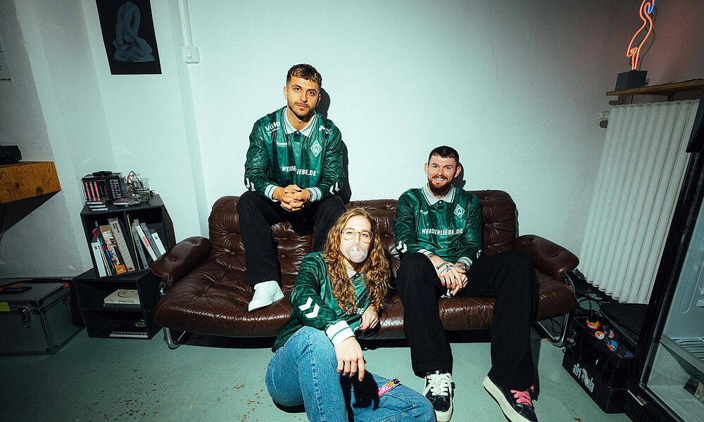 Fifabio, Saskia Matheis und Oliver Burke sitzen auf einer Couch. Sie tragen das neue eSPORTS-Trikot.