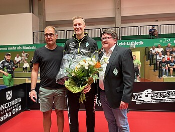 Mattias Falck mit einem Blumenstrauß in der Hand.