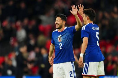 Yukinari Sugawara klatscht mit einem Kollegen in der Nationalmannschaft ab.