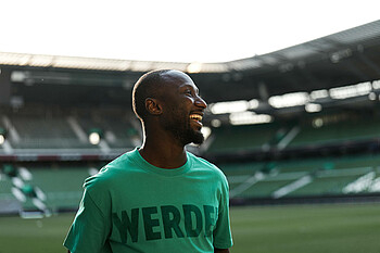 Naby Keïta steht im Inneren des wohninvest WESERSTADION. 