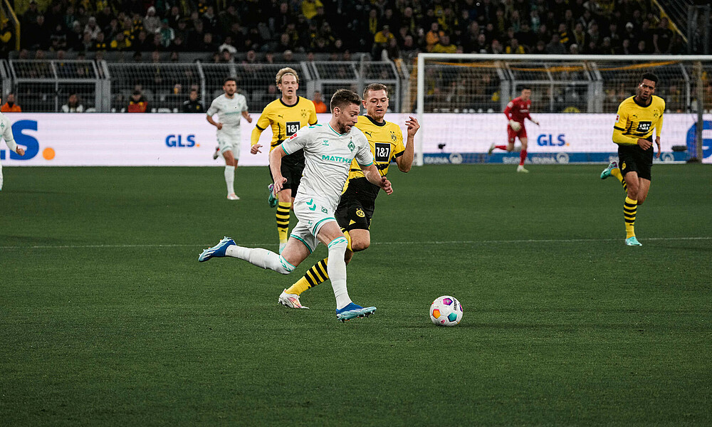 null Mitchell Weiser läuft mit dem Ball vor dem Dortmunder Gegenspieler.