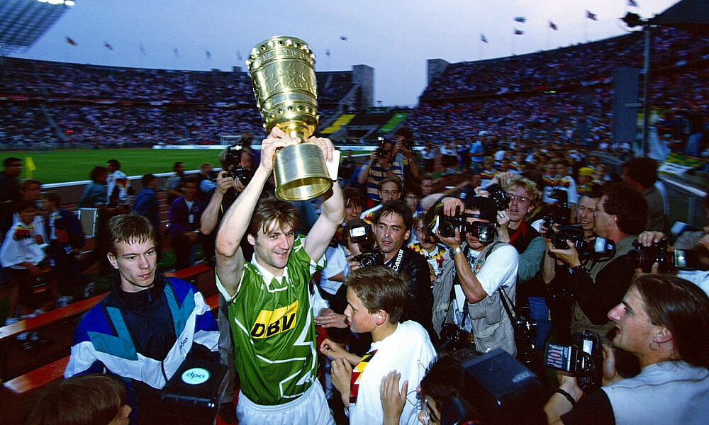 Dietmar Beiersdorfer streckt den DFB-Pokal in die Höhe.