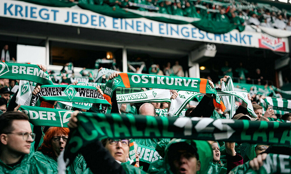 Werder-Fans, die ihren Schal in die Luft strecken