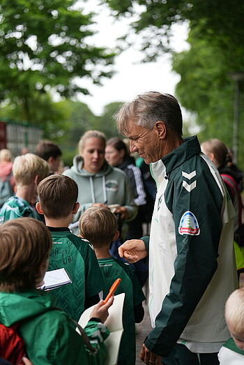 null Horst Steffen schreibt nach dem Training Autogramme für Kinder