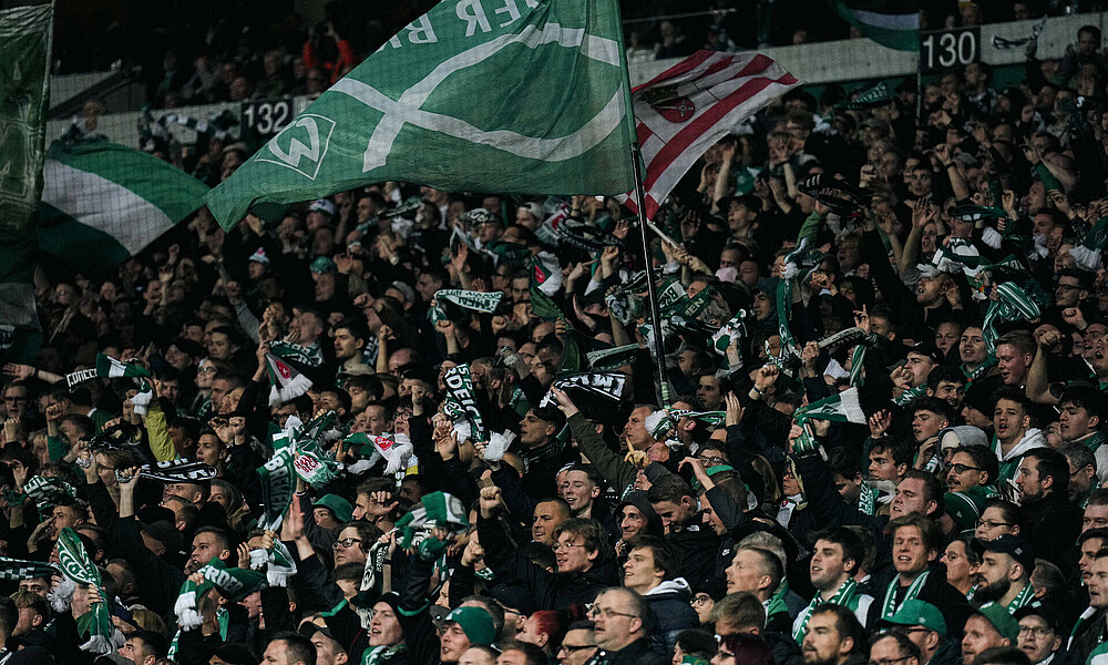 Die Ostkurve schwenkt Fahnen und feuert die Mannschaft gegen Schalke an. 