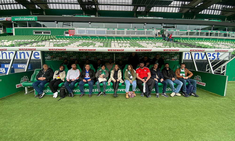 Die internationalen Fans auf der Trainerbank im Stadion.