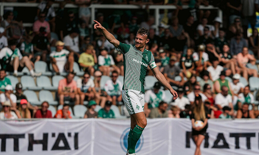 Christian Groß dirigiert mit der Kapitänsbinde am Arm. 