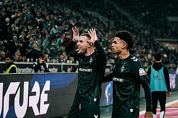 Marvin Ducksch macht seinen Jubel mit Händen an den Ohren und rausgestreckter Zunge. Hinter ihm steht Justin Njinmah.