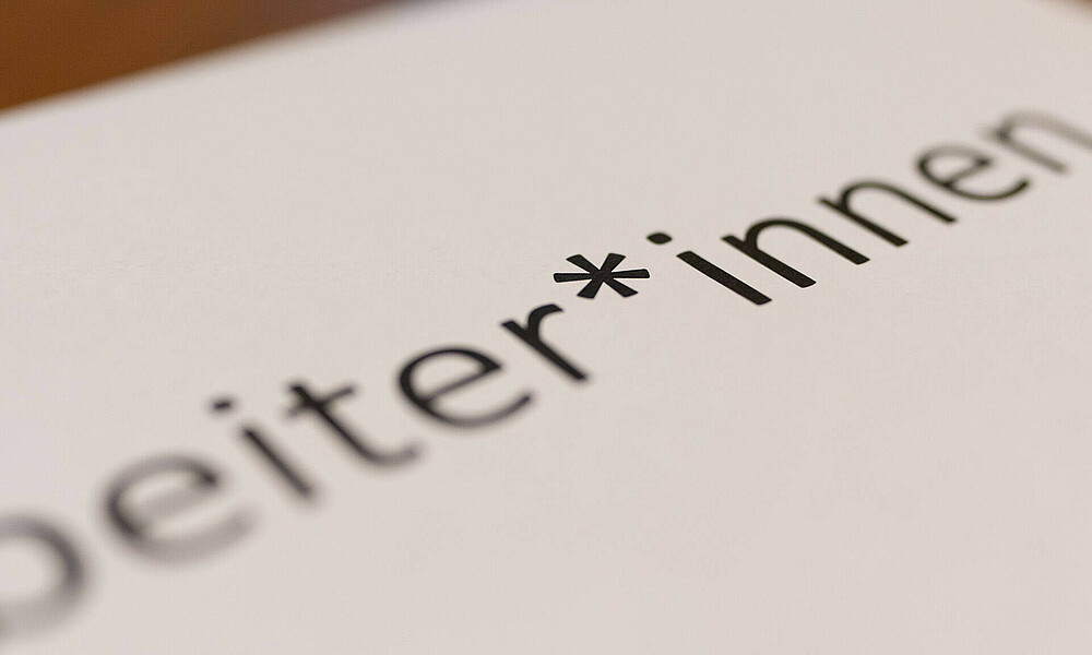 Nahaufnahme des Gendersternchens im Wort Mitarbeiter*innen.