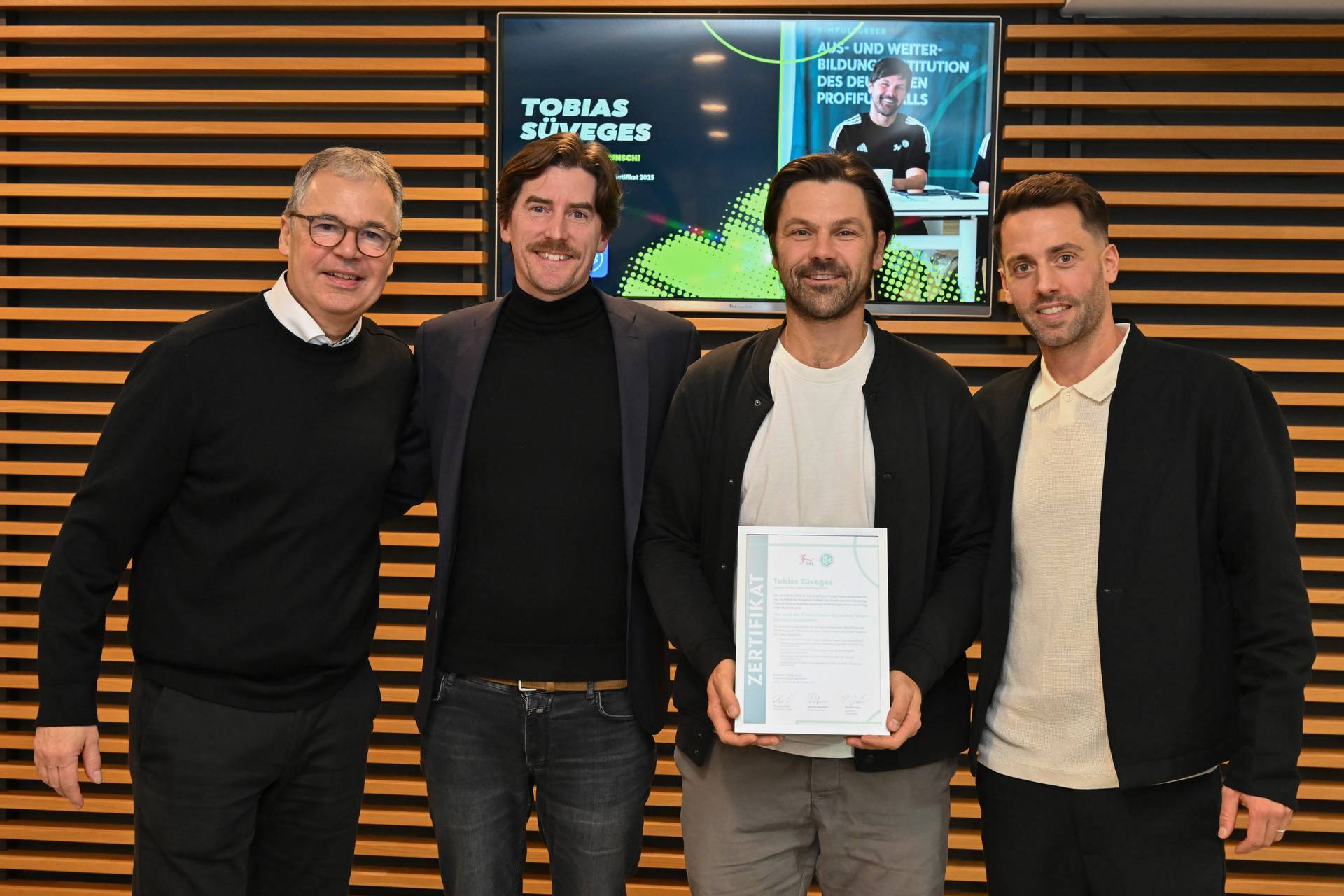 Tobias Süveges (Zweiter von rechts in einer Reihe von vier Personen) hält seine Urkunde in der Hand.