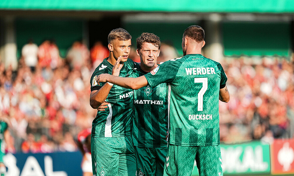 Topp, Stage und Ducksch jubeln gemeinsam im Pokalspiel in Cottbus