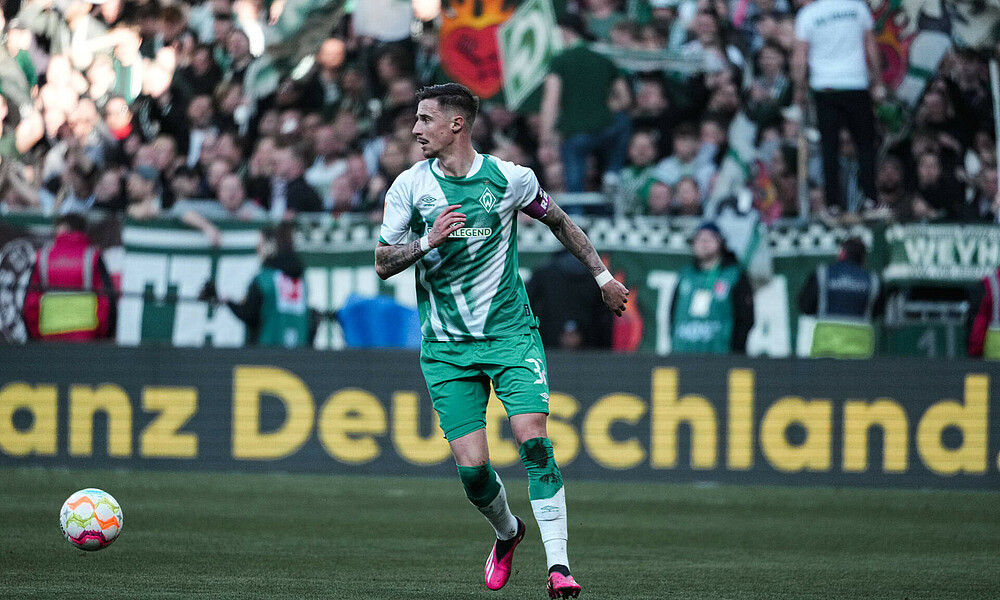 Marco Friedl mit Ball vor der Ostkurve.