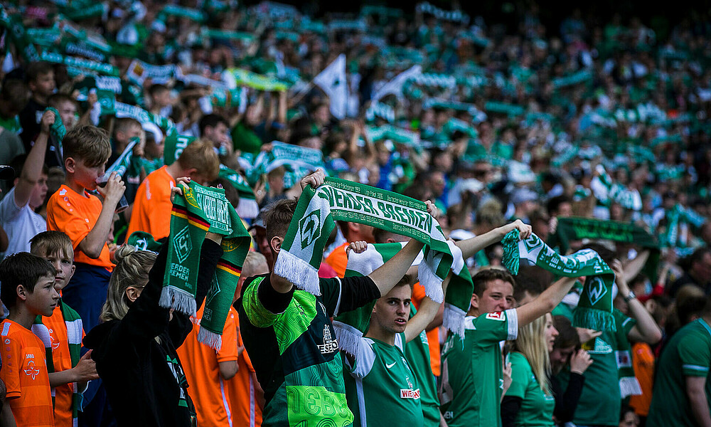 null Die Werder-Fans im Stadion halten bei der Hymne ihren Schal hoch.