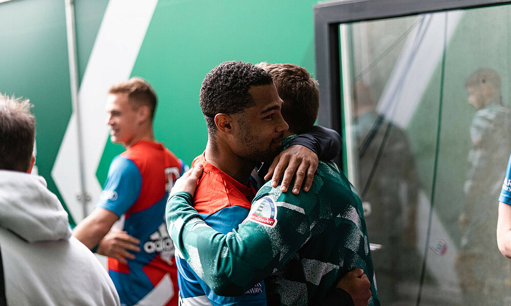 null Serge Gnabry und Mitchell Weiser umarmen sich.