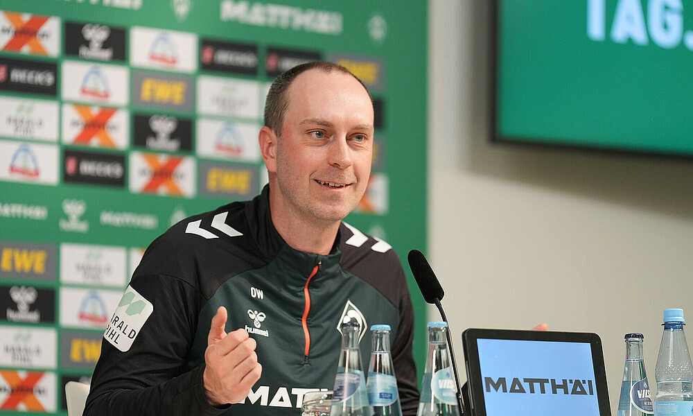 Ole Werner gestikuliert auf dem Podium bei der Pressekonferenz