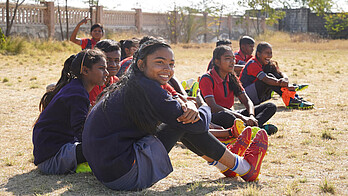 Mädchen sitzen auf dem Boden und warten auf ihren Einsatz.