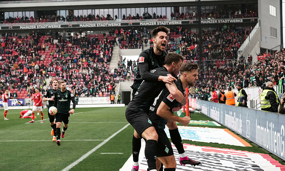 Niclas Füllkrug wird von Ilia Gruev und Maximilian Philipp geherzt. 