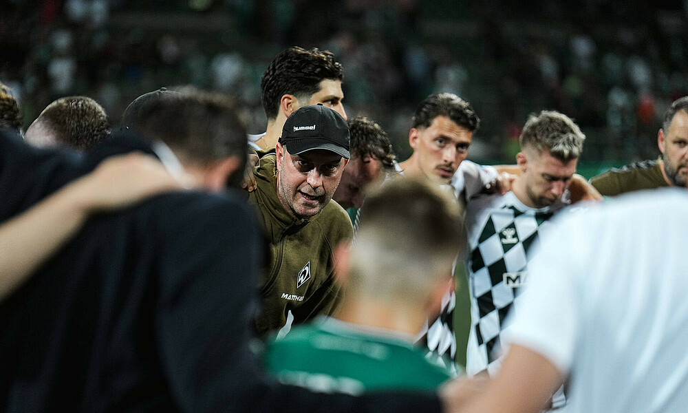 Werders Mannschaftskreis nach dem Schlusspfiff, Ole Werner spricht.