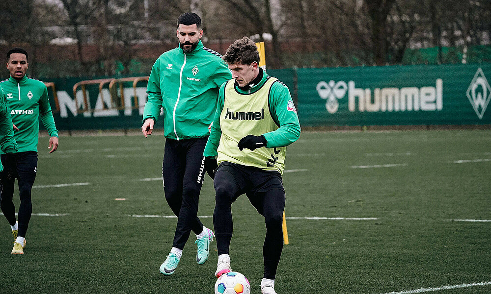 Jens Stage mit dem Ball am Fuß, im Hintergrund Anthony Jung.