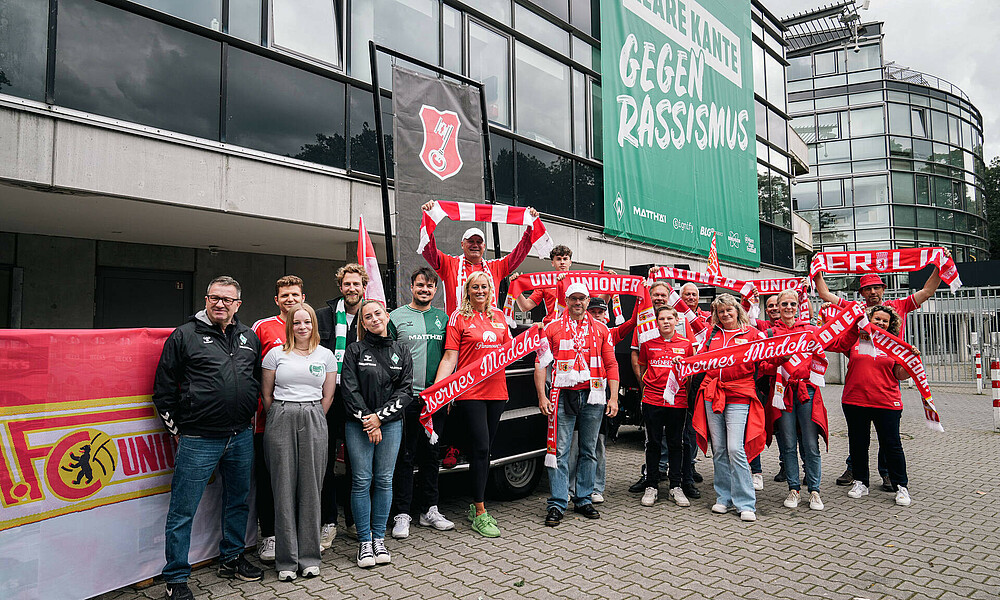 null Union-Fans und Werder-Vertreter:innen bei der Bierübergabe.