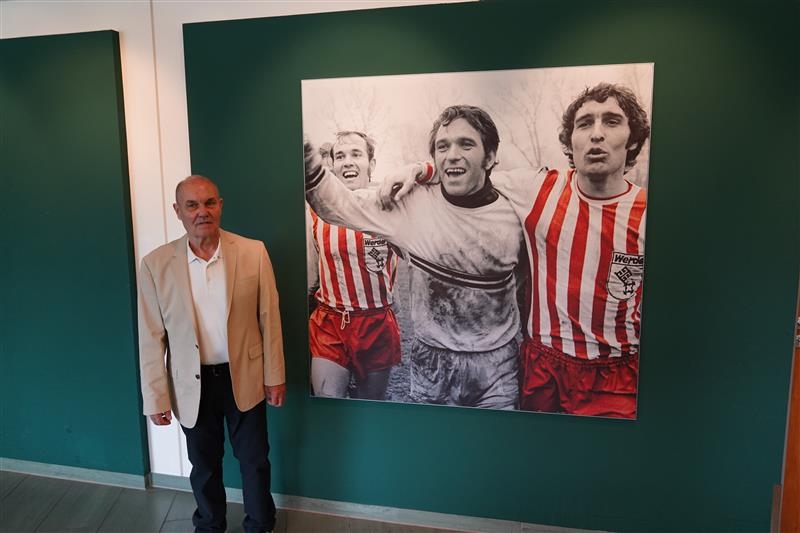 Kalli Kamp steht vor dem Bild.