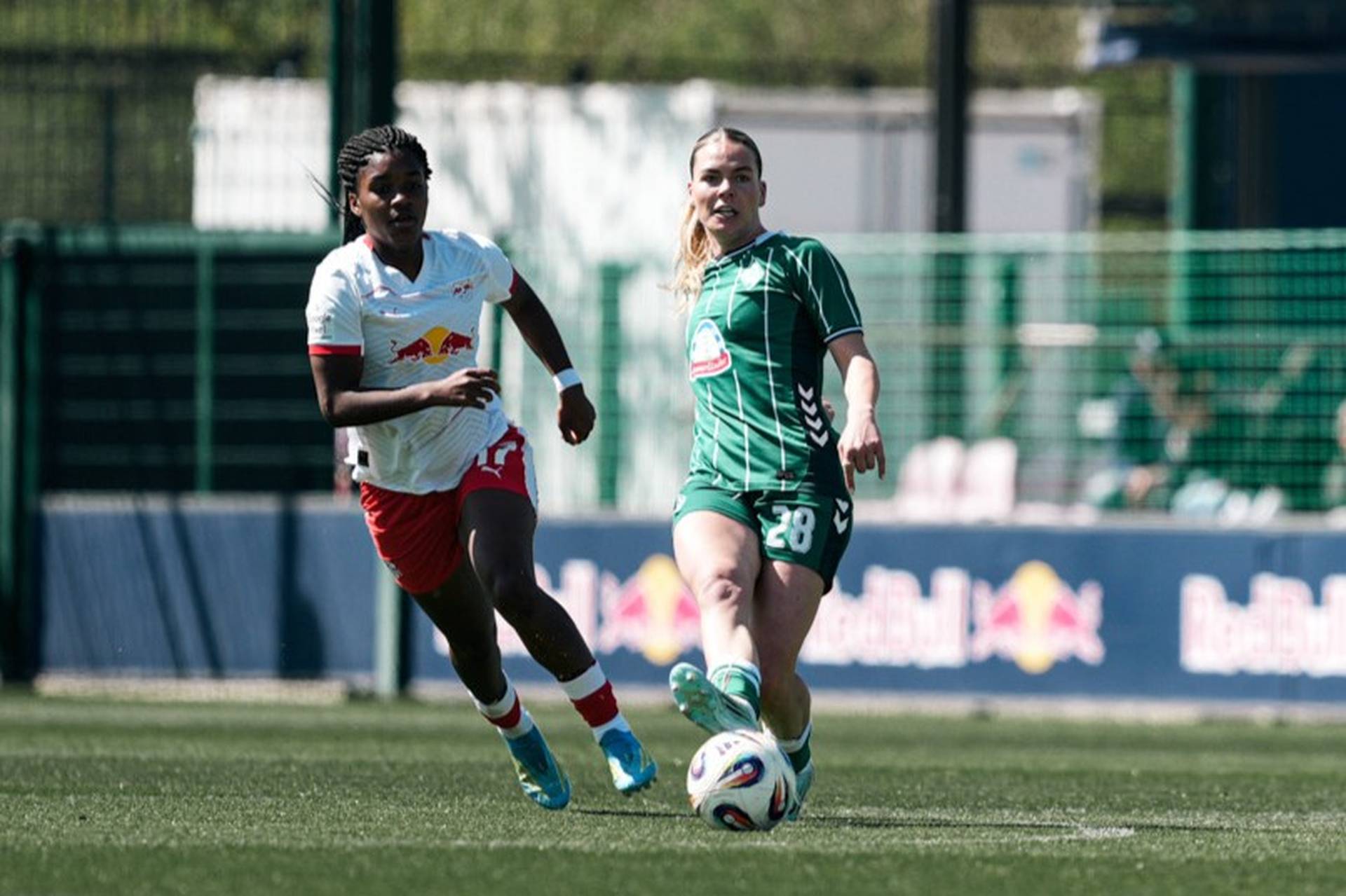 Juliane Wirtz spielt einen Pass, ihre Gegenspielerin und sie schauen dem Ball hinterher.