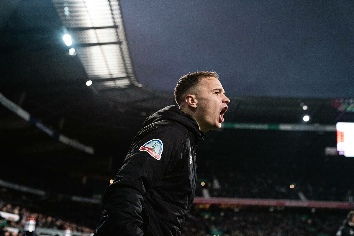 Niklas Schmidt brüllt in Richtung Spielfeld. 