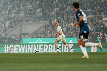 null Senne Lynen auf dem Platz mit Ball am Fuß.