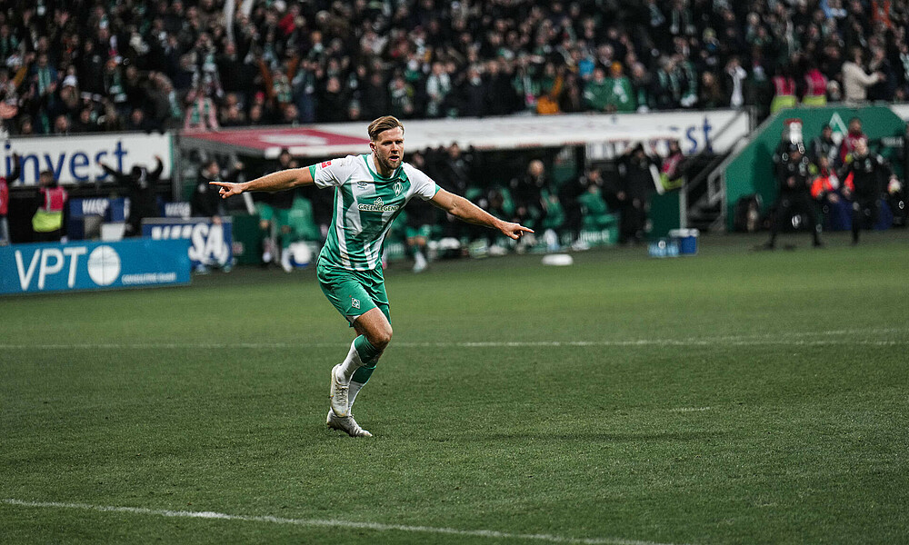 null Niclas Füllkrug jubelt mit ausgestreckten Armen.