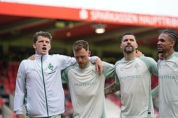 Jens Stage feiert mit seinen Teamkollegen vor der Kurve. 